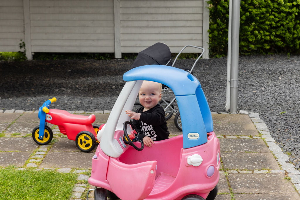 Glad barn leger med plastikbil i Krista Sønderups private børnepasning